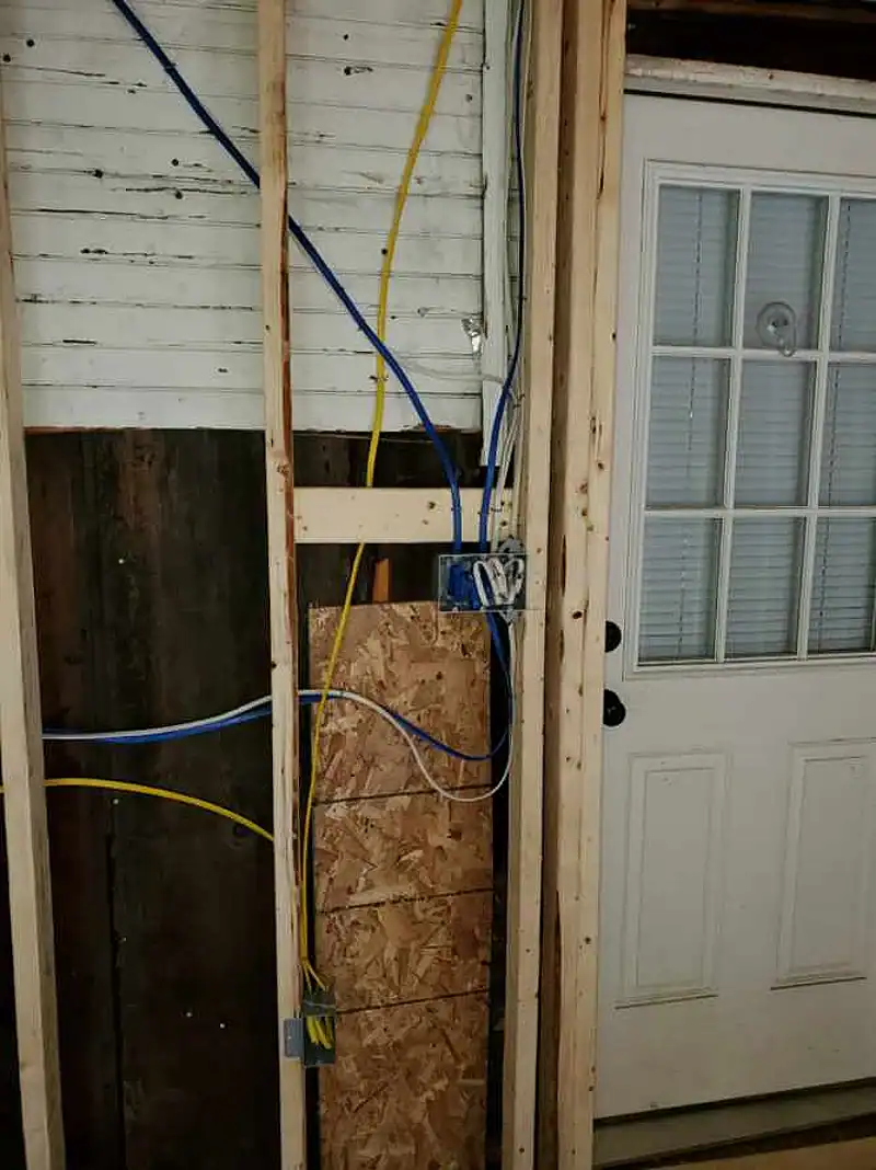 New wiring run through framing beside an exterior door in an addition