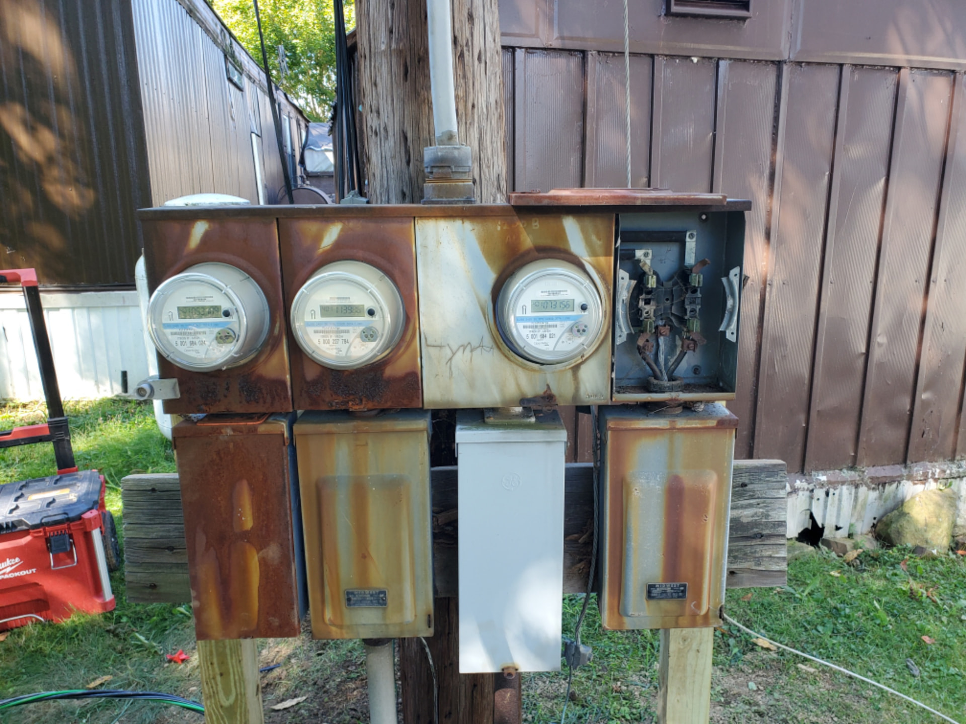 Weathered three-meter electrical service equipment before replacement