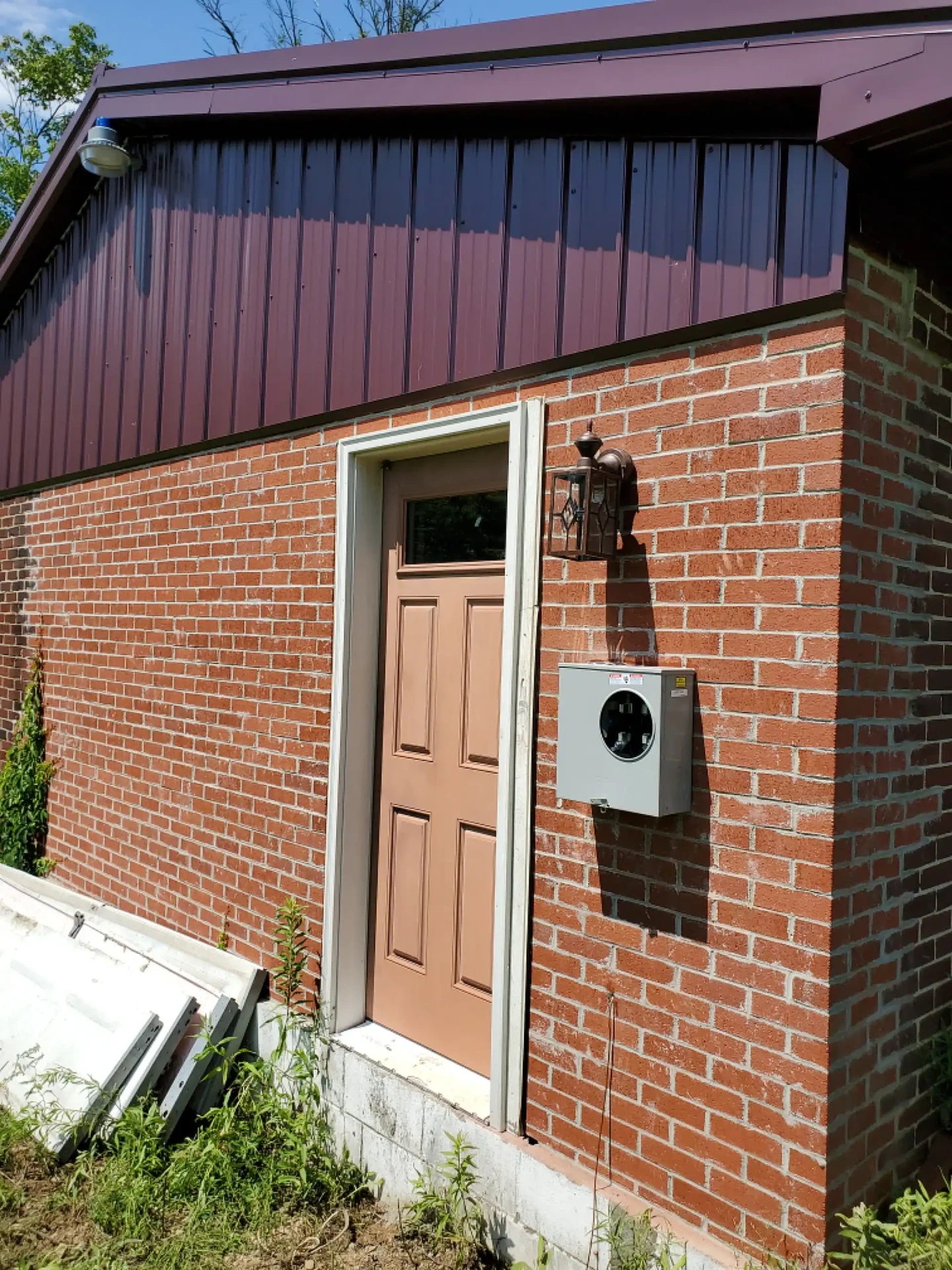 New meter base and lantern light on a brick outbuilding